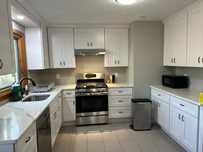 a kitchen with white cabinets and a stove top oven at M2 Comfortable Room near Rutgers U, hospitals in New Brunswick