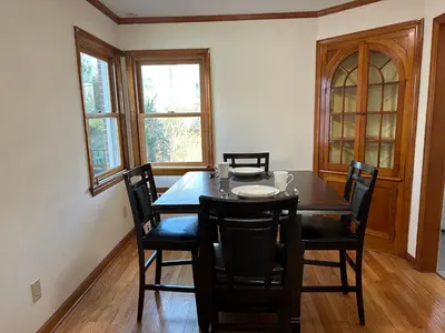 a dining room with a wooden table and chairs at M2 Comfortable Room near Rutgers U, hospitals in New Brunswick
