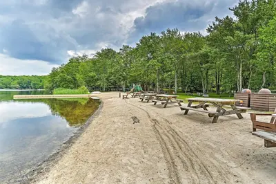 a row of picnic tables on the shore of a lake at Pet-Friendly Home with Deck at Big Bass Lake! in Gouldsboro