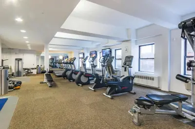 a gym with a row of treadmills and machines at Chelsea 1BR w Gym nr Penn Station MSG NYC-528 in New York