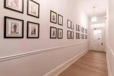 a hallway with framed pictures on a wall at Thena Hotel - Oversized 1 Bedroom in Philadelphia
