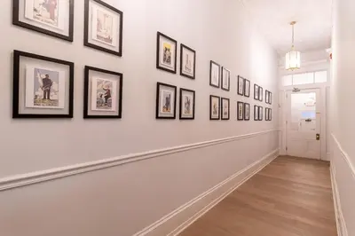 a hallway with framed pictures on the wall at Thena Hotel - Large Studio in Philadelphia