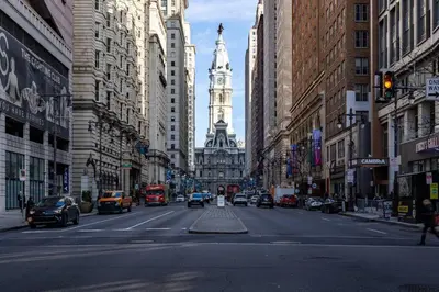 a busy city street with a clock tower in the distance at Thena Hotel - Large Studio in Philadelphia