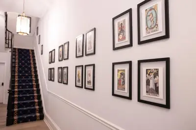 a hallway with framed pictures on a wall at Thena Hotel - Cozy Studio in Philadelphia