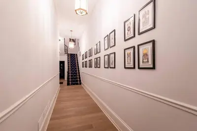 a hallway with a bunch of pictures on the wall at Thena Hotel - Cozy Studio in Philadelphia