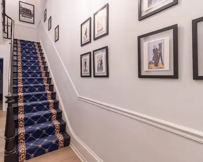 a staircase with framed pictures on the wall at Thena Hotel - Beautiful 1 Bedroom in Philadelphia