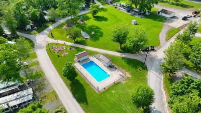 an aerial view of a house with a swimming pool in a park at Cozy Cabin Within Campground in Mifflinburg