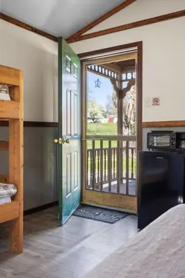a room with a door open to a balcony at Cozy Cabin Within Campground in Mifflinburg