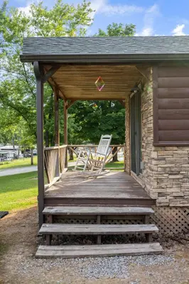 a wooden porch with rocking chairs on a house at Deluxe Cabin Within Campground in Mifflinburg