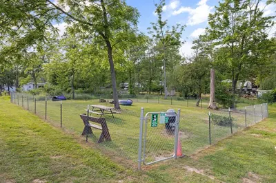 a fence with a bench and a picnic table in a park at Entire House within Campground in Mifflinburg
