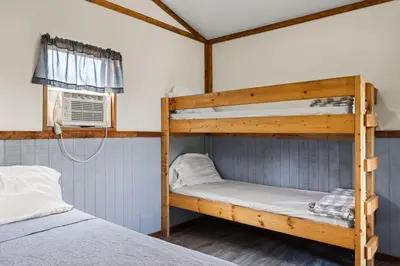 two bunk beds in a room with a window at Cozy Cabin4 Within Campground in Mifflinburg