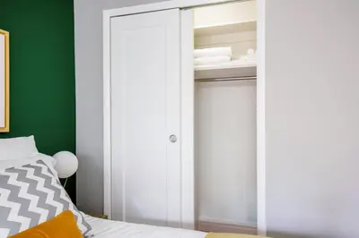 a bedroom with white closet doors and a bed at Midtown E Studio w Great light Gym NYC-139 in New York